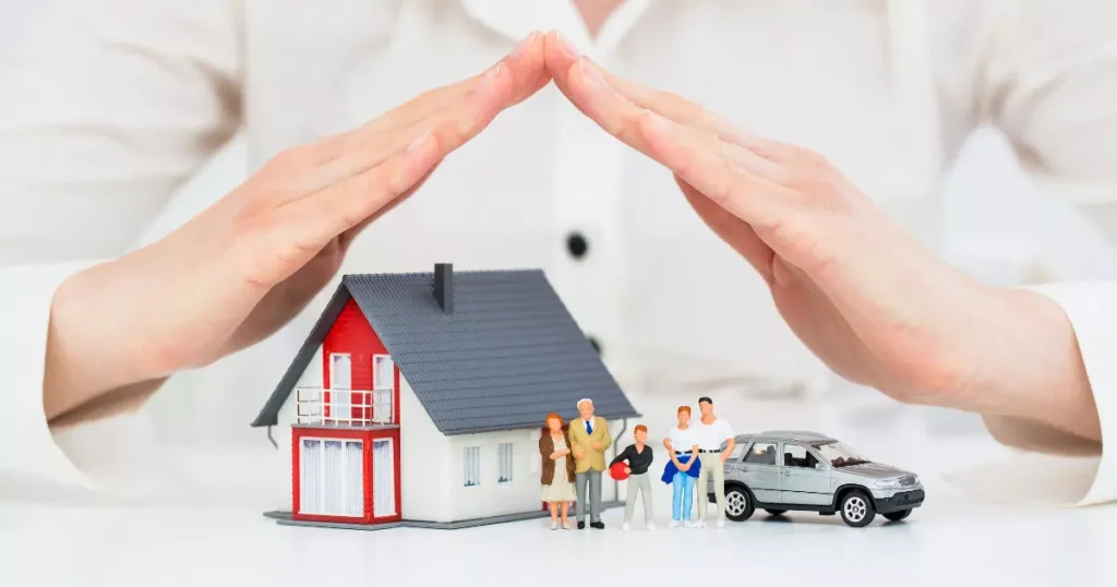 A hands covering a house with a roof 