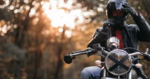 Biker adjusts helmet showing motorcycle insurance safety